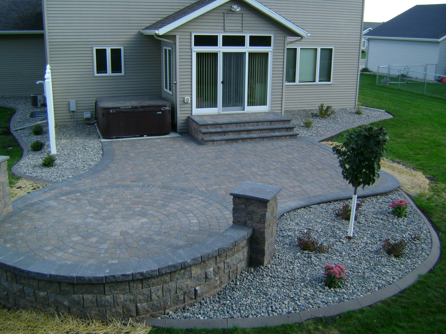 Landscaping Around Patio
 Earth Tone Paver Patio with Sitting Wall and Rock Fill