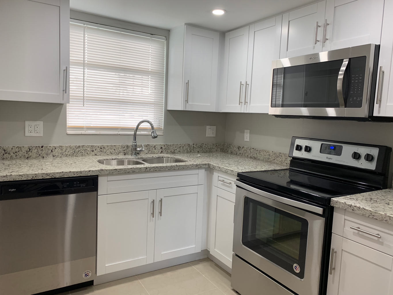 Small L Shaped Kitchen
 Small Kitchen Remodel with White Shaker Cabinets — Miami
