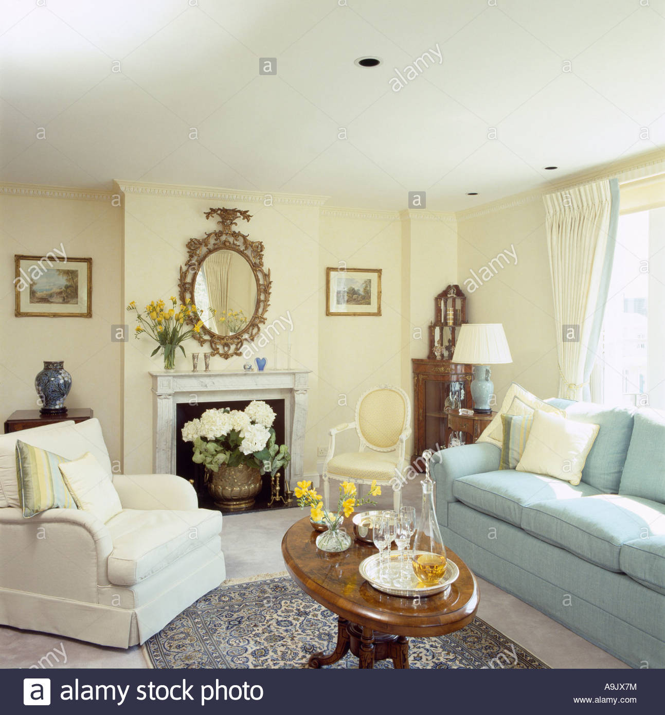 Light Yellow Living Room
 White armchair and pastel blue sofa in pale yellow sitting